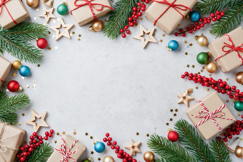 Christmas decorations arranged as a border frame on a light surface with copyspace in center