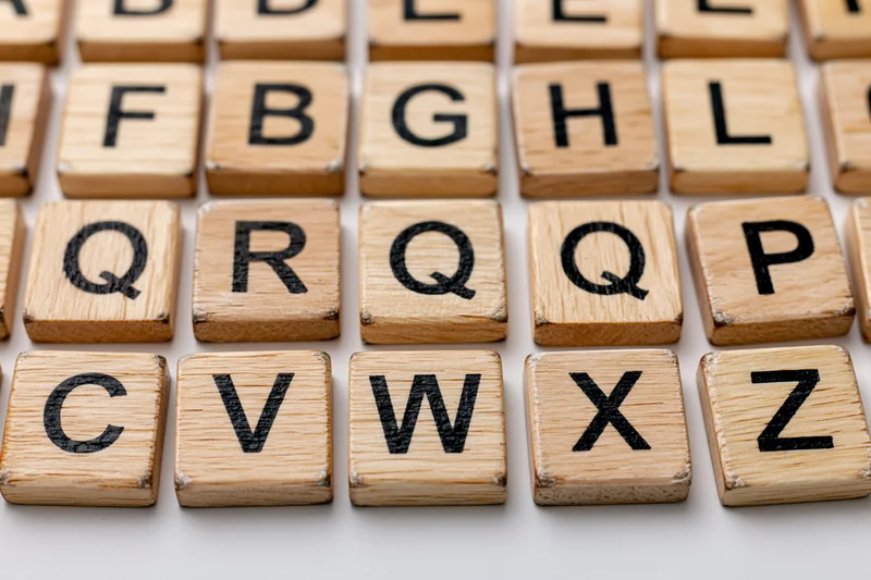Wooden letter tiles arranged in alphabetical grid on light surface