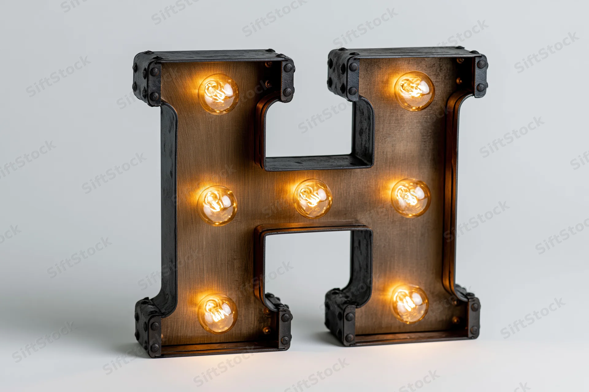 Large illuminated marquee letter h with edison bulbs on white background
