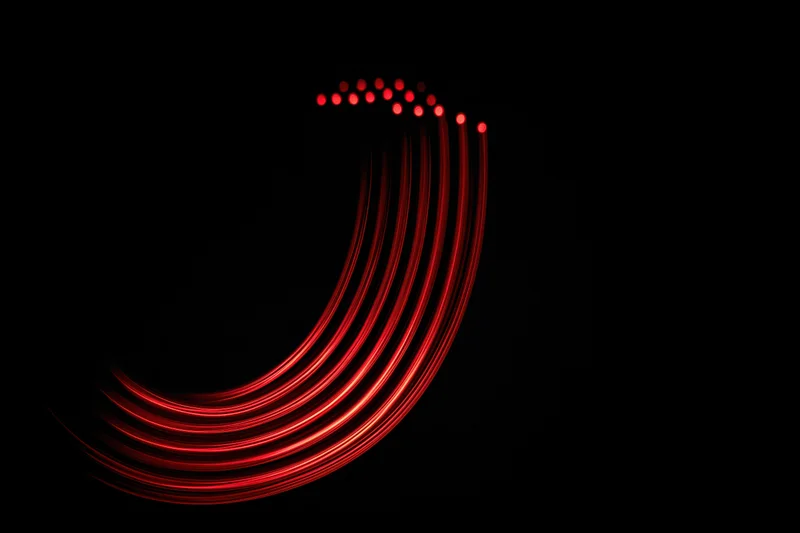 Red light trails forming a lowercase letter j against a black background
