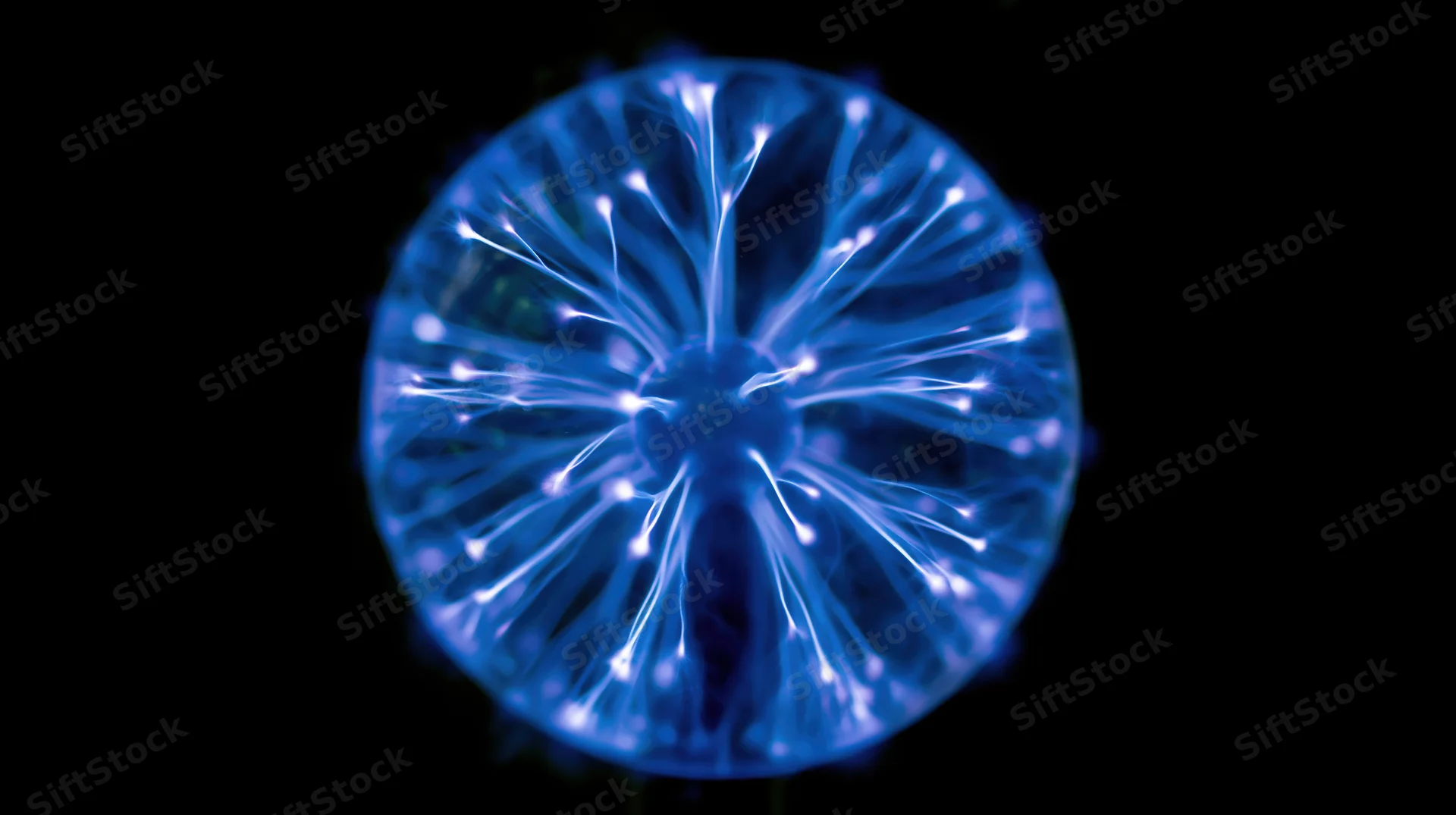Glowing plasma ball with electric filaments radiating from center against dark background