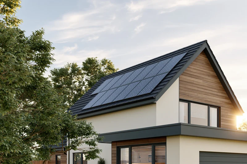 Modern suburban house with solar panels on the roof at sunset