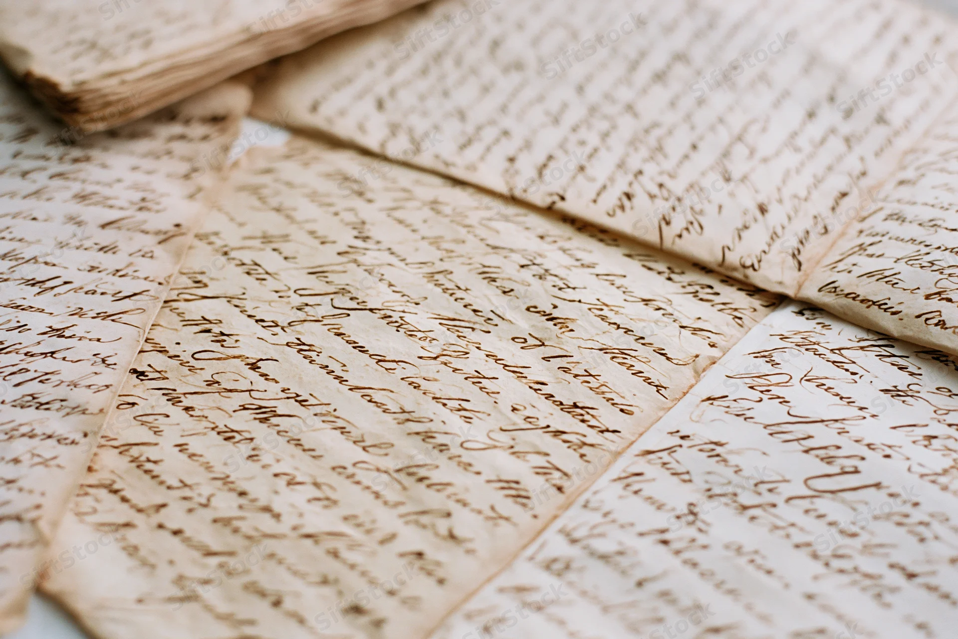 Antique handwritten letters layered and overlapping on a flat surface