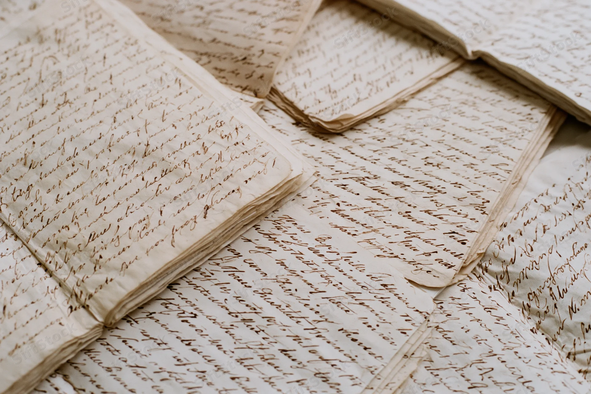 Antique handwritten letters layered and overlapping on a flat surface