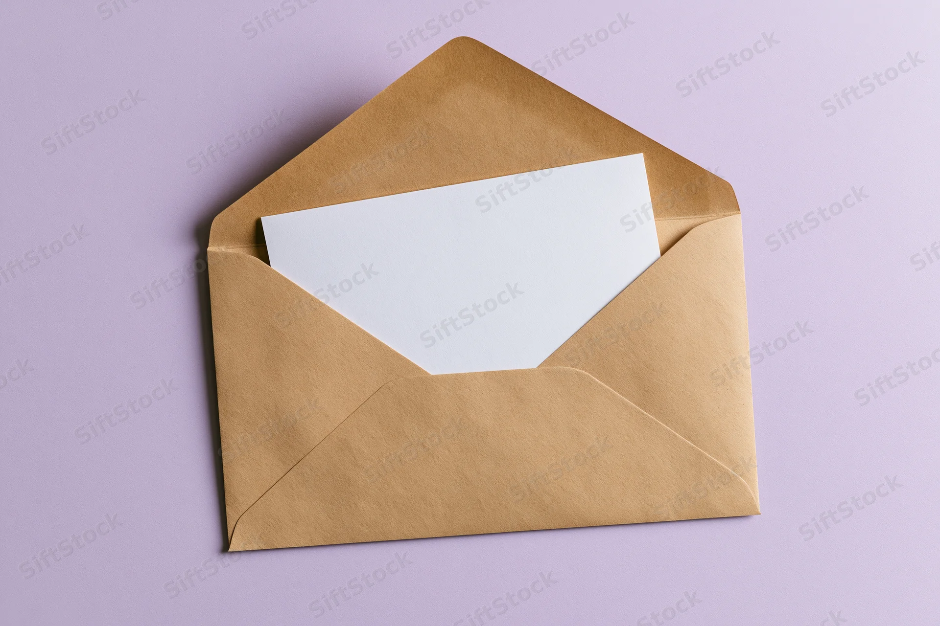 Open kraft paper envelope with blank white card inside on lavender background
