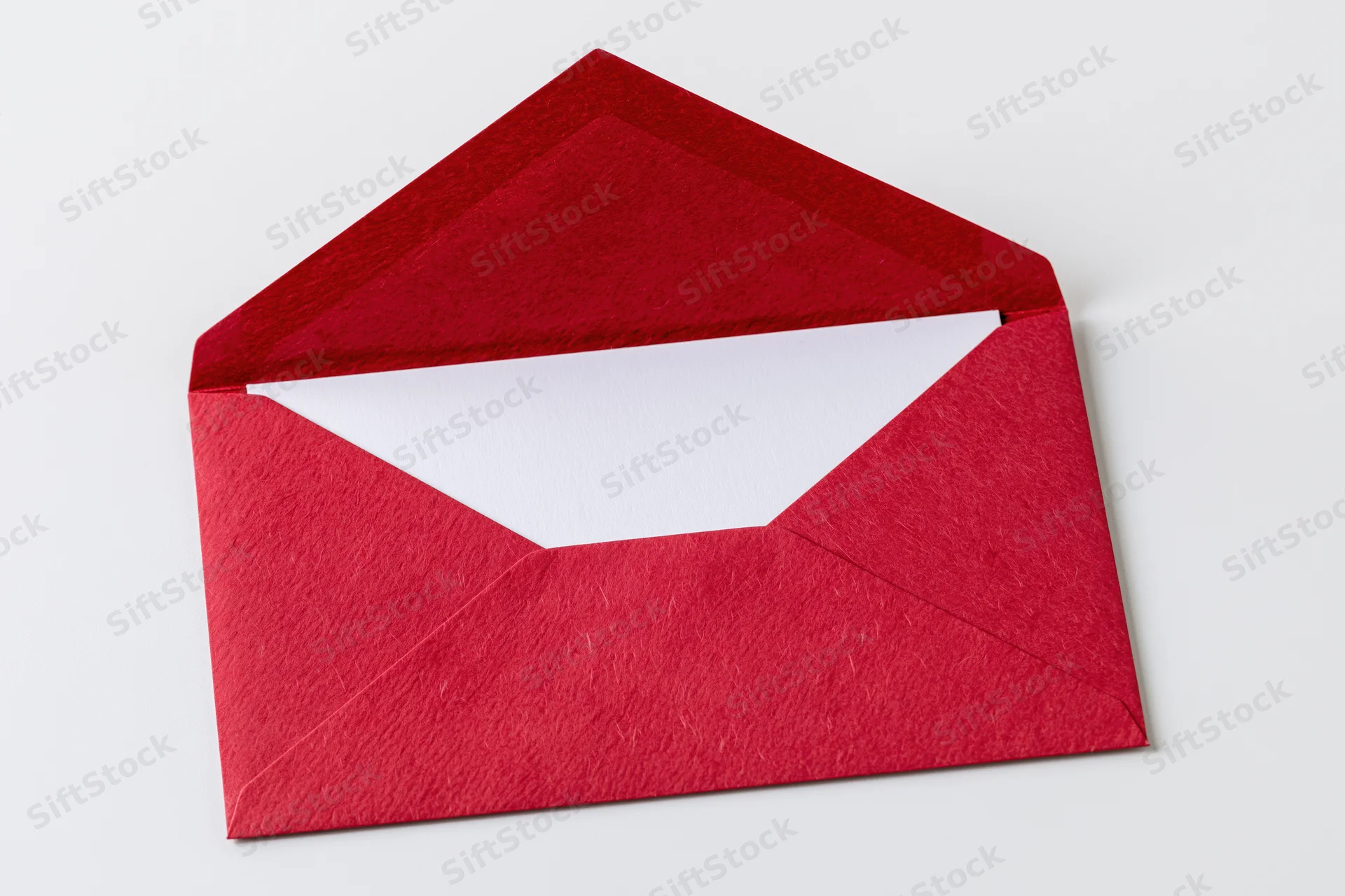 Open red paper envelope with blank white card inside on white background