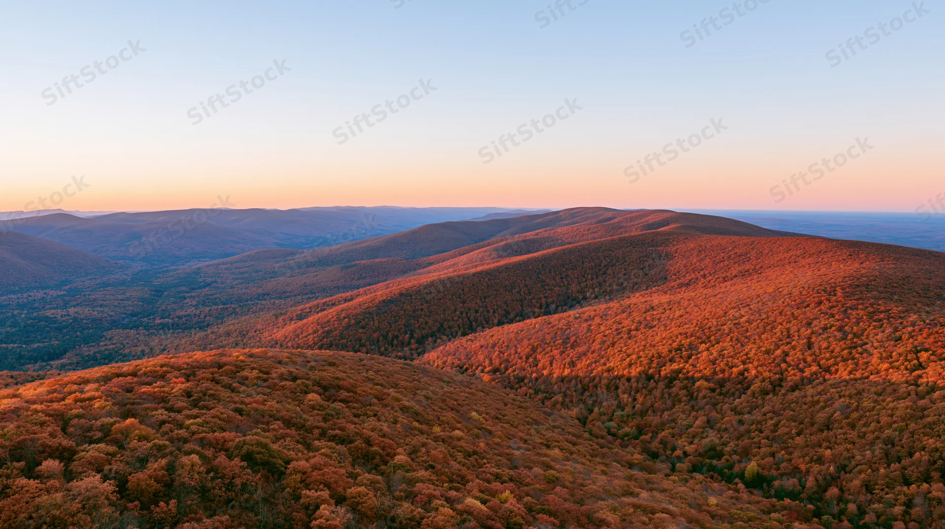 Panoramic view of autumn forested mountains at sunset from a high ridge