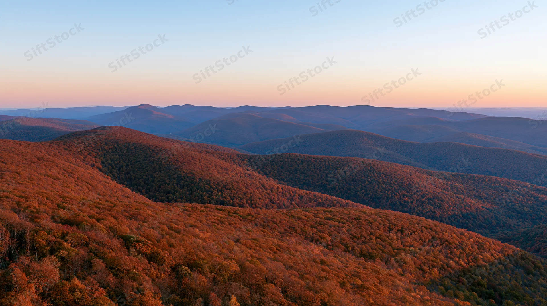 Panoramic view of rolling forested mountains at sunset in autumn