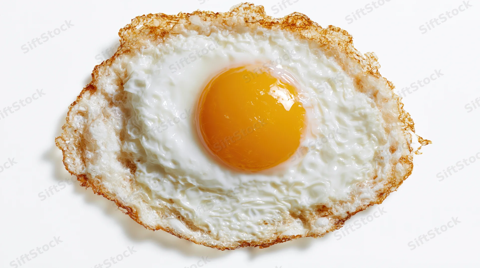 Single fried egg with runny yolk and crispy edges viewed from directly above on white background