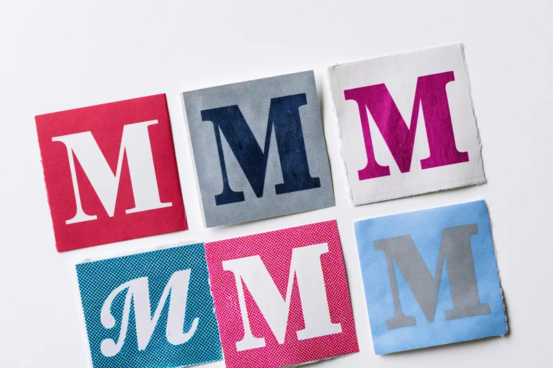 Six cut-out letter m squares arranged in a grid on white background