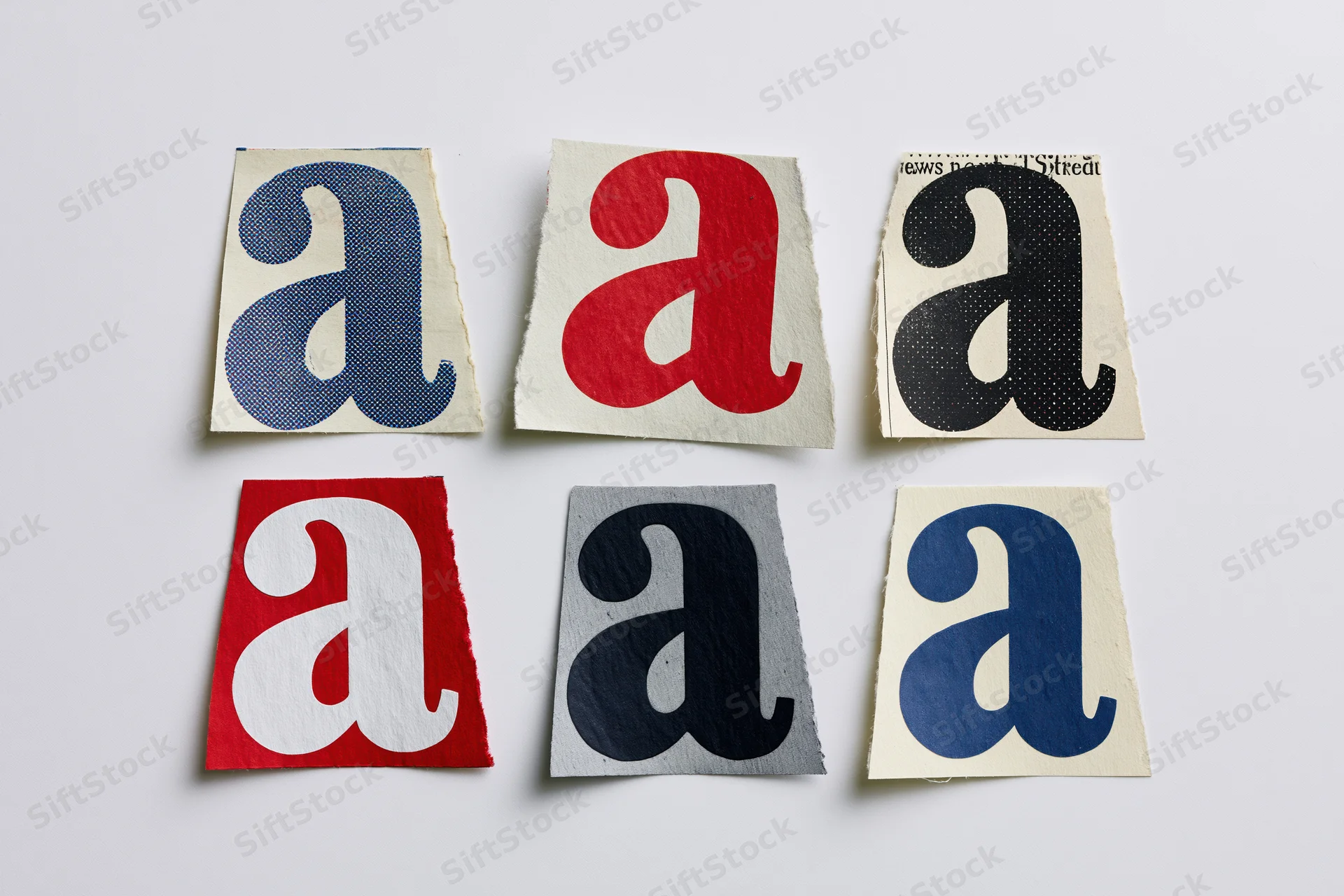 Six cut-out magazine letter a clippings arranged in two rows on white background