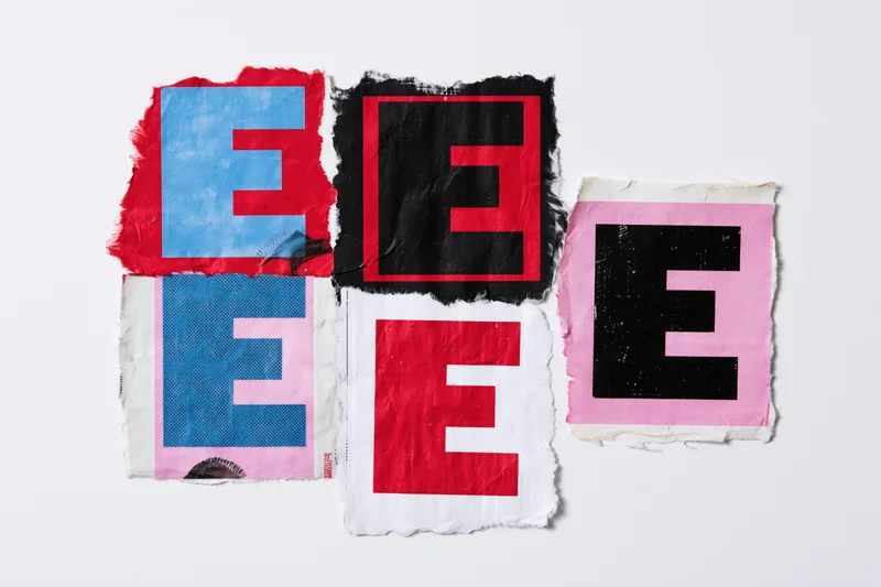 Torn paper clippings with letter e in various colors and textures arranged on white background