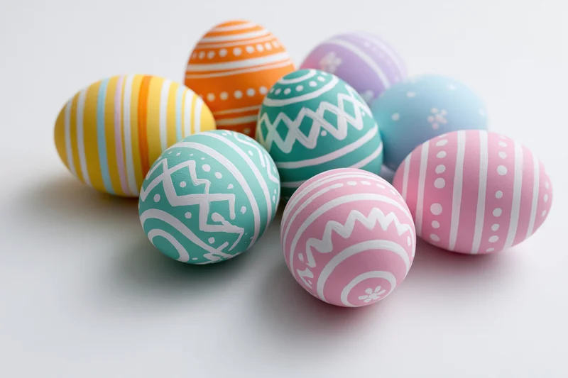 Colorful hand-painted easter eggs grouped on white surface