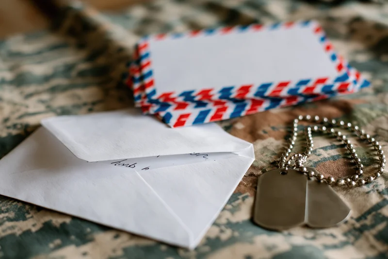 Dogtags and airmail envelopes on camouflage fabric