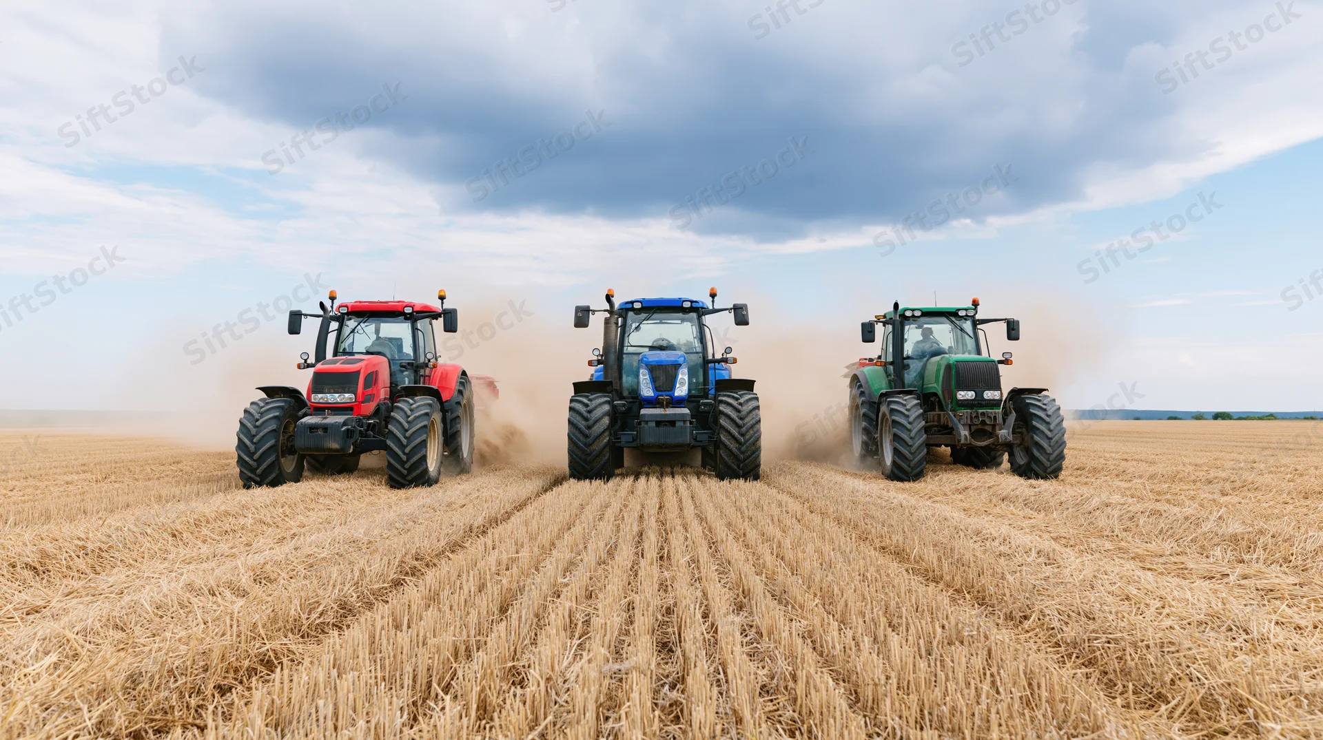 Three tractors driving side by side across a harvested field under a cloudy sky