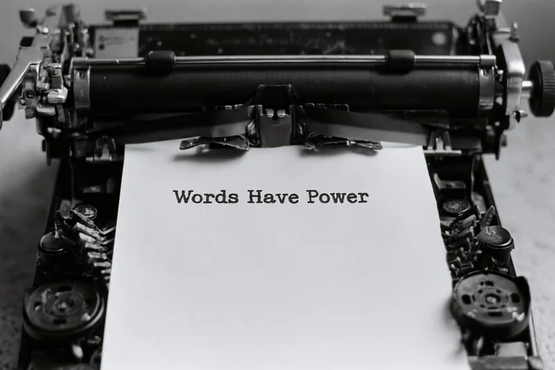 Vintage mechanical typewriter with paper displaying the typed phrase words have power