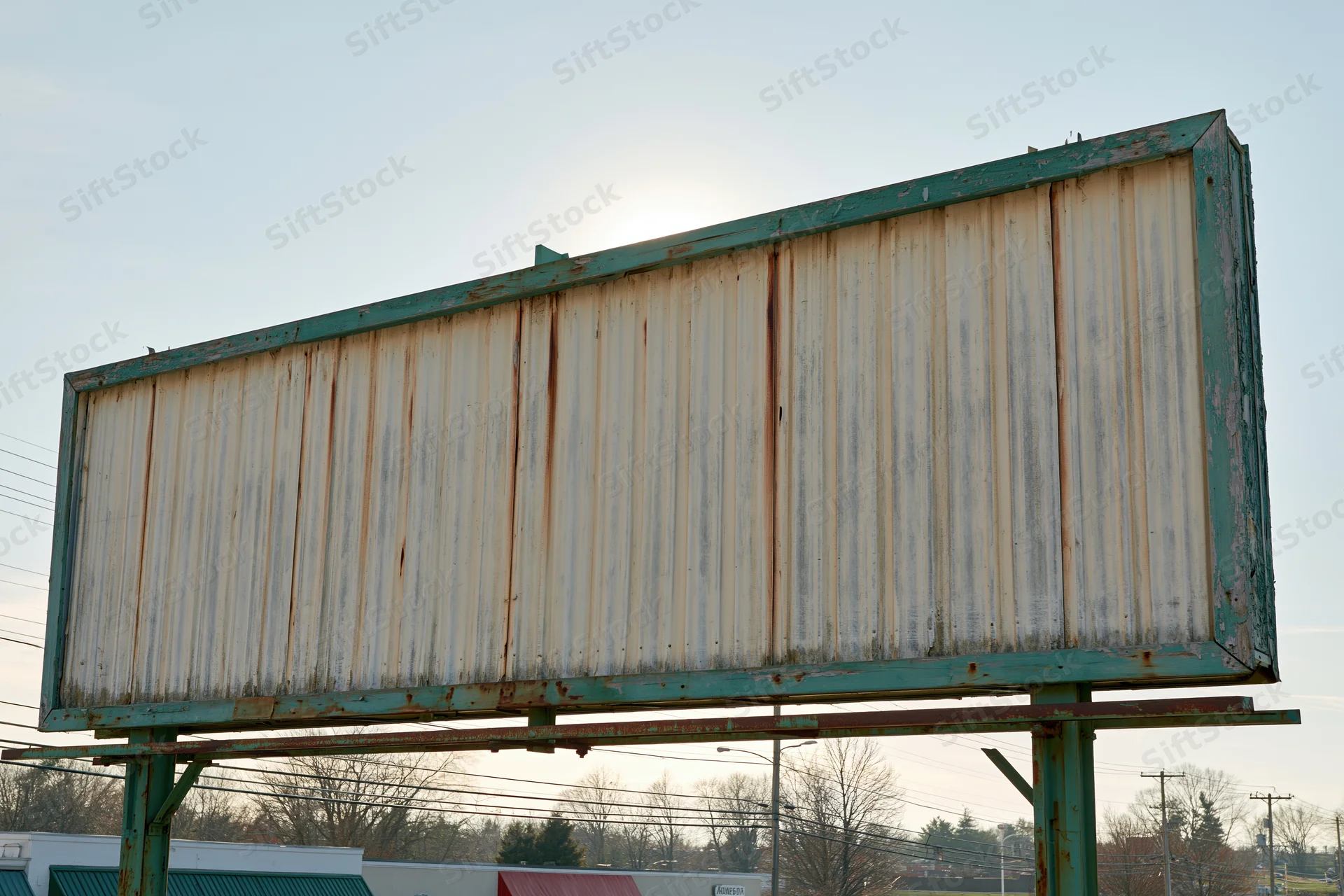 Weathered roadside billboard with blank letterboard under clear sky
