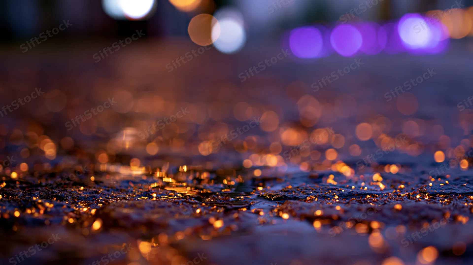 Wet cobblestone pavement reflecting glowing embers and city lights at night