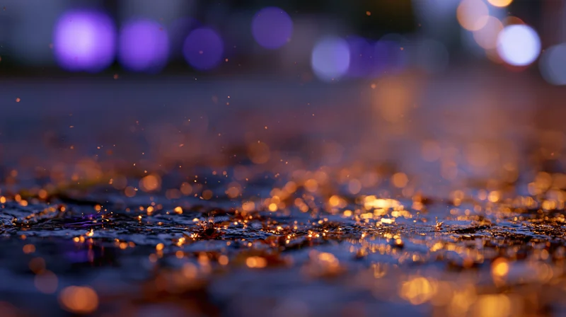 Glowing embers scattered across wet cobblestone pavement at night with blurred city lights in background