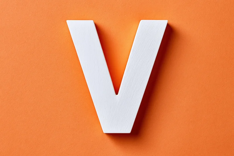 White painted wooden letter v centered on textured orange background