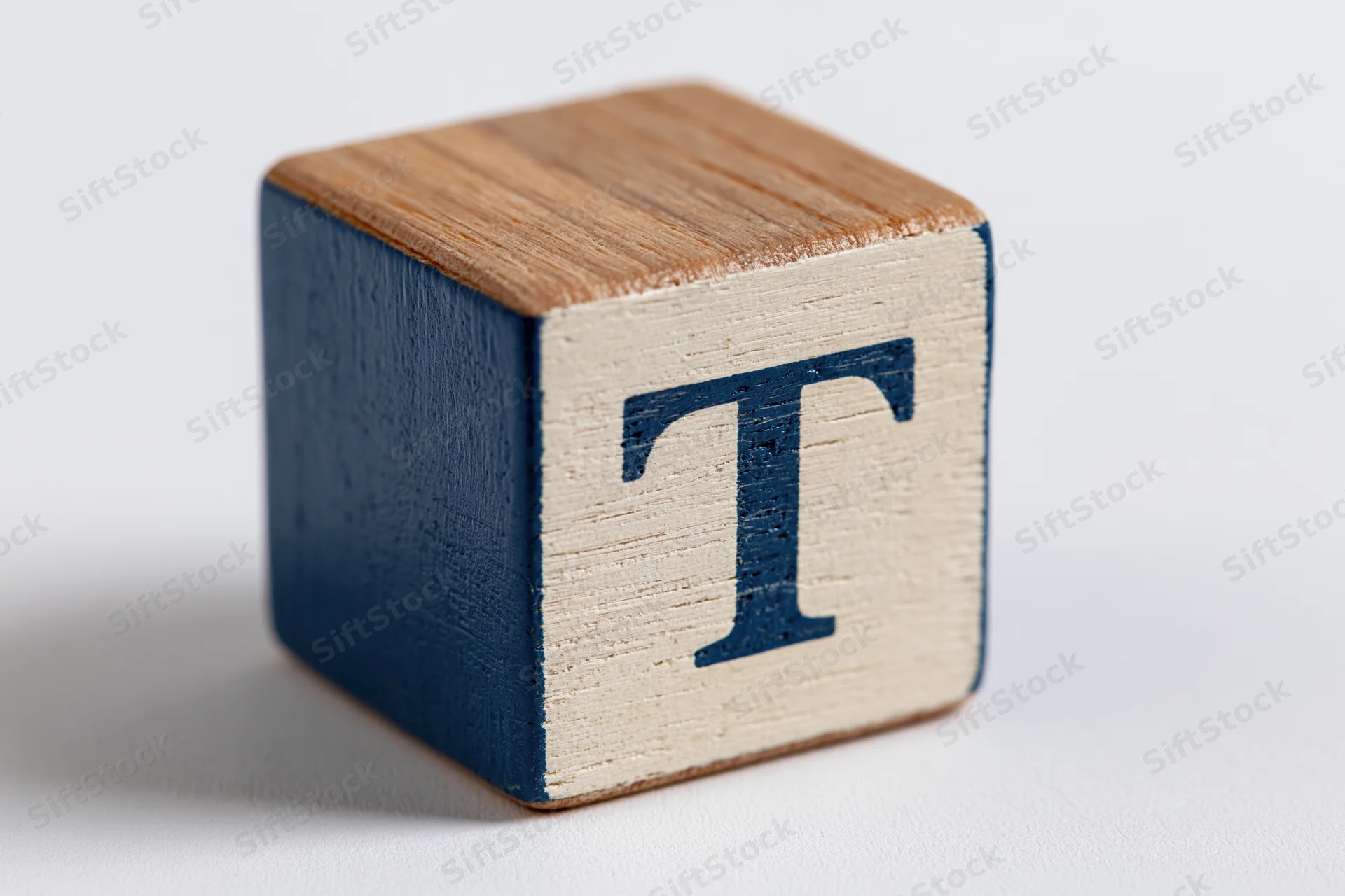 Wooden alphabet block with letter t on white background
