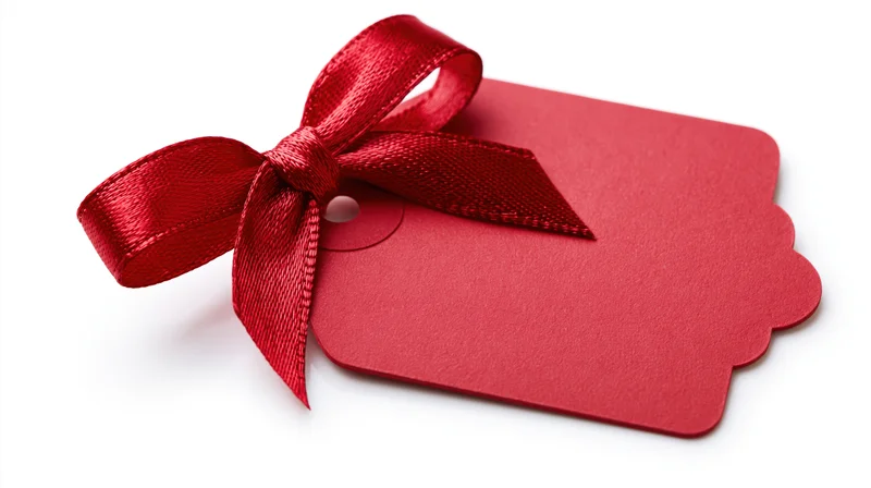 Red gift tag with satin ribbon bow on white background