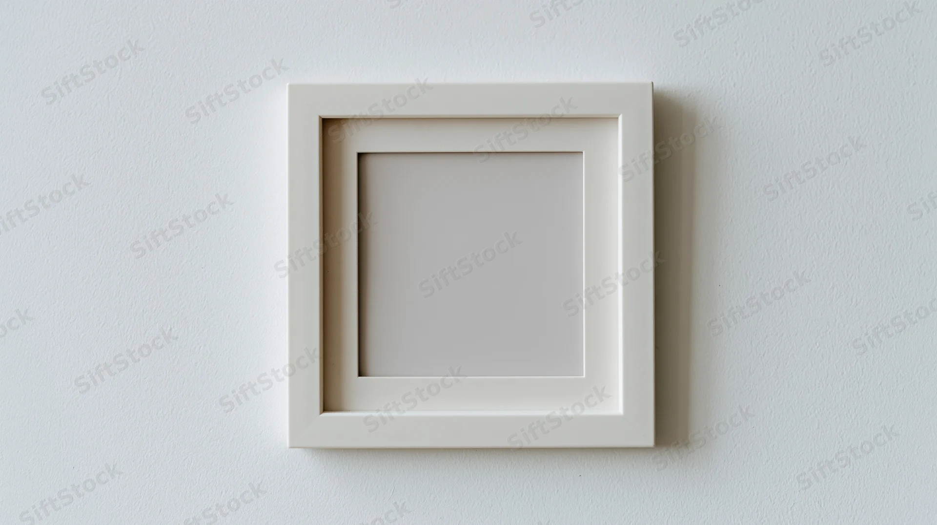 White square frame hanging on a plain wall with empty center for display