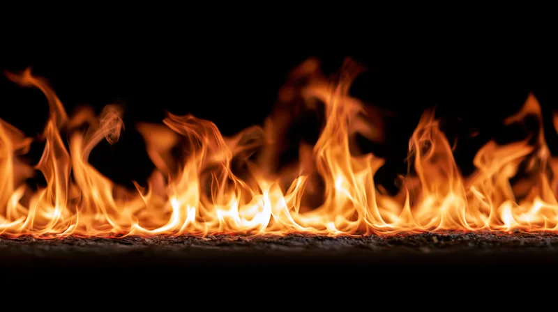 Horizontal band of flames burning across a dark surface