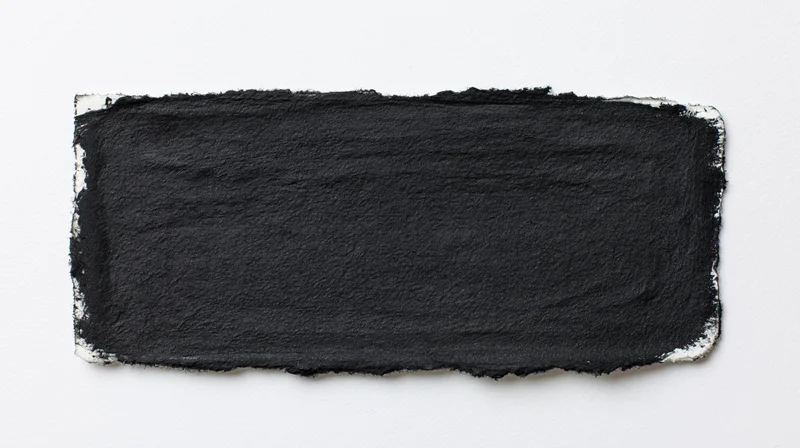 Black ink wash painted on white paper with textured edges and copyspace