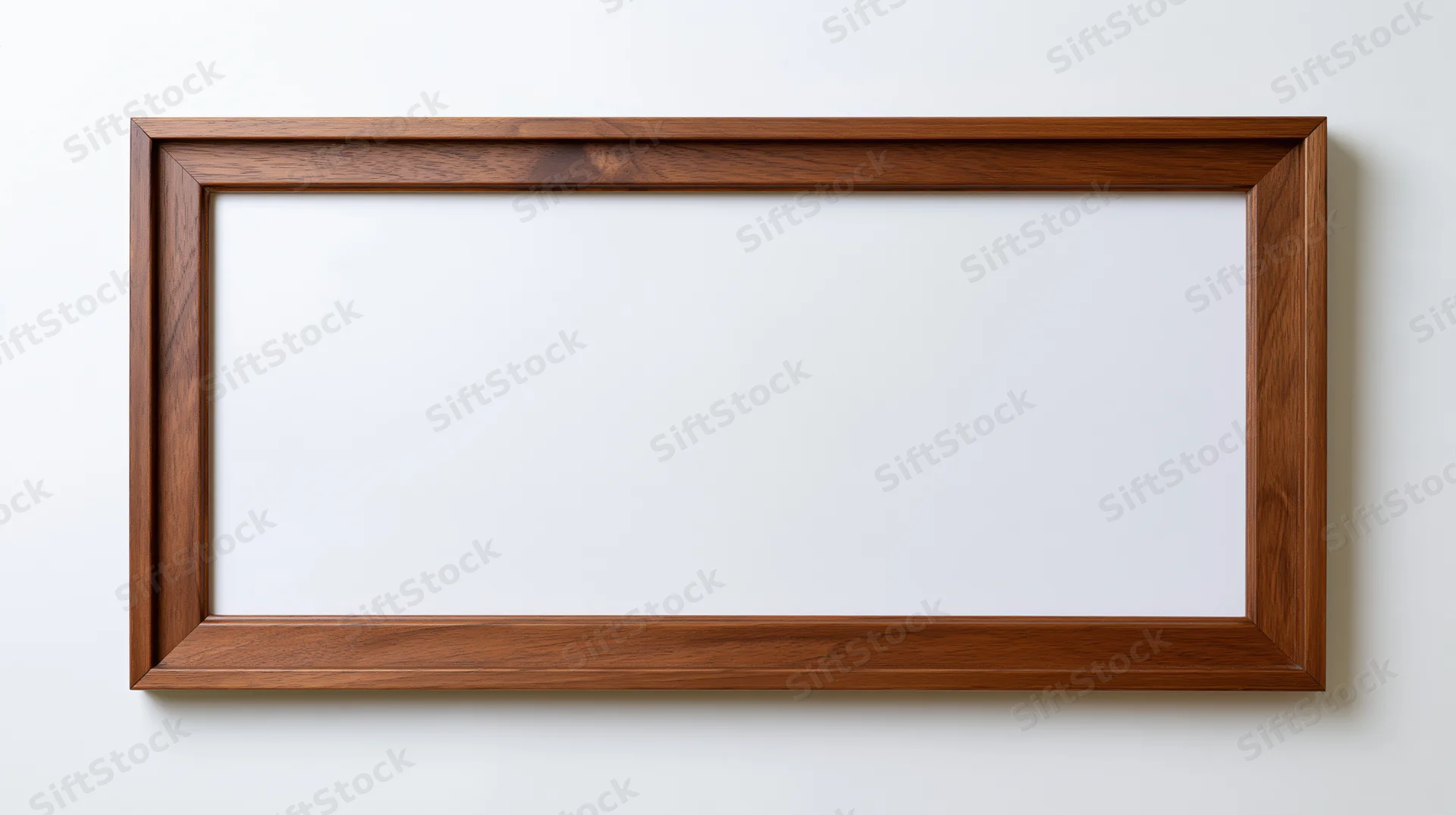 Rectangular wooden picture frame hanging on a white wall with blank interior space