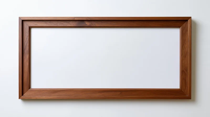 Rectangular wooden picture frame hanging on a white wall with blank interior space