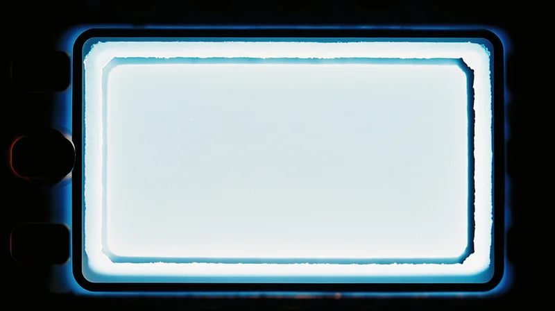 Blank 35mm film frame illuminated from behind with blue glow, dark background