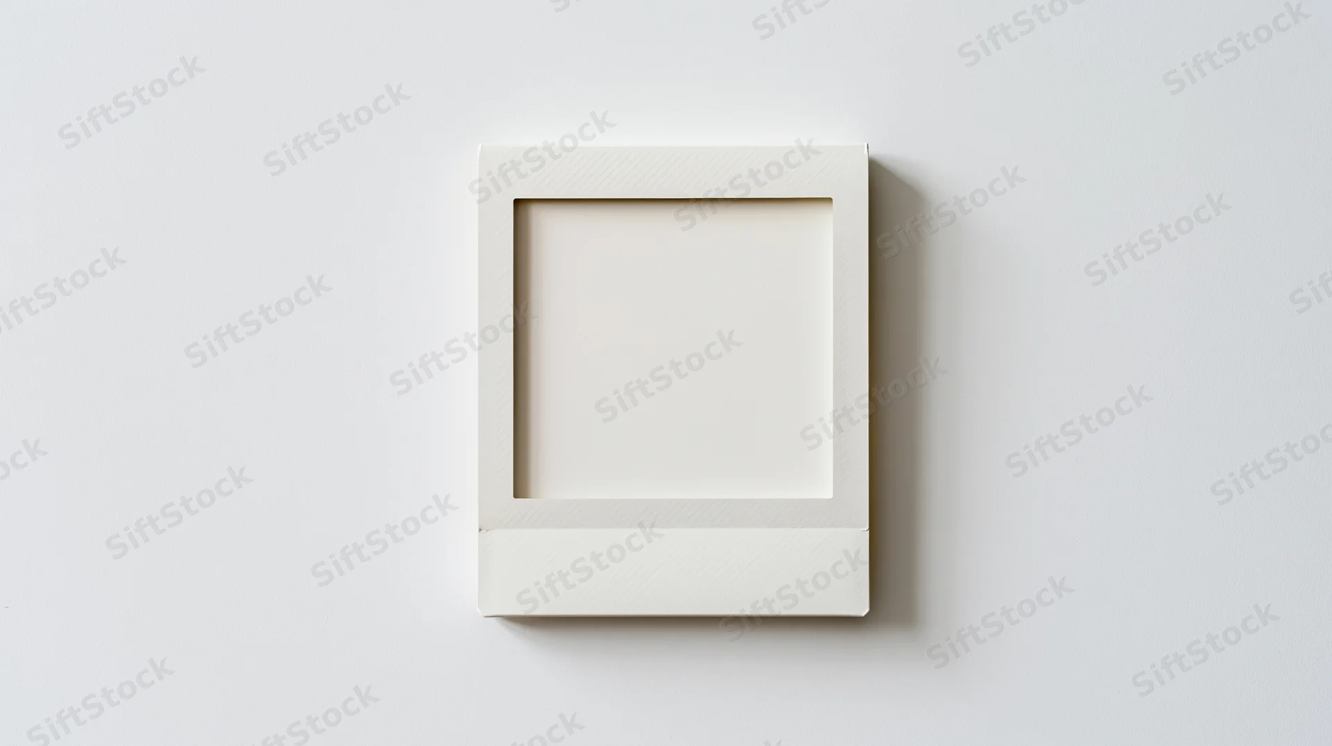 Blank polaroid photo frame lying flat on white surface