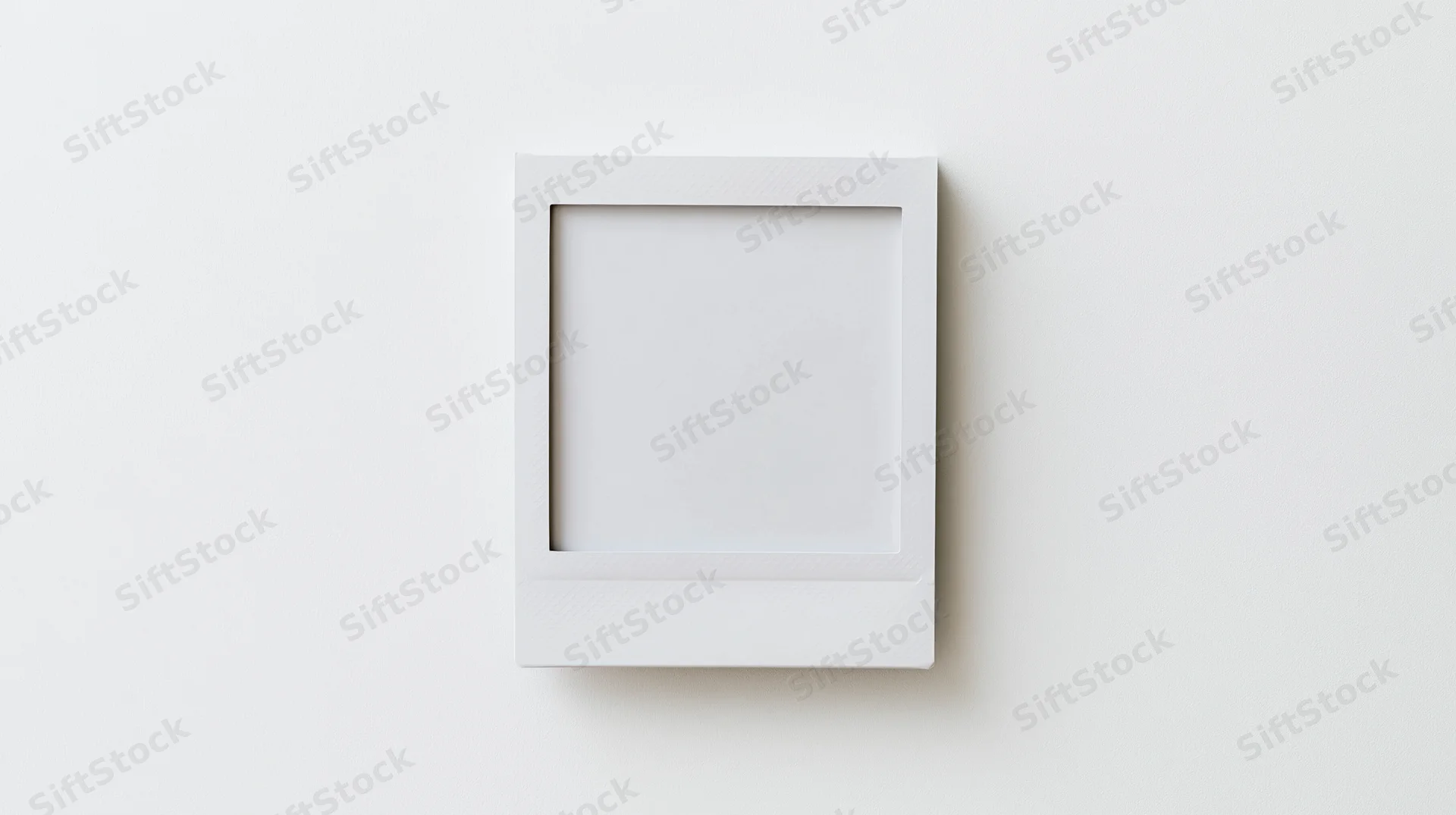 Blank polaroid photo frame lying flat on white surface