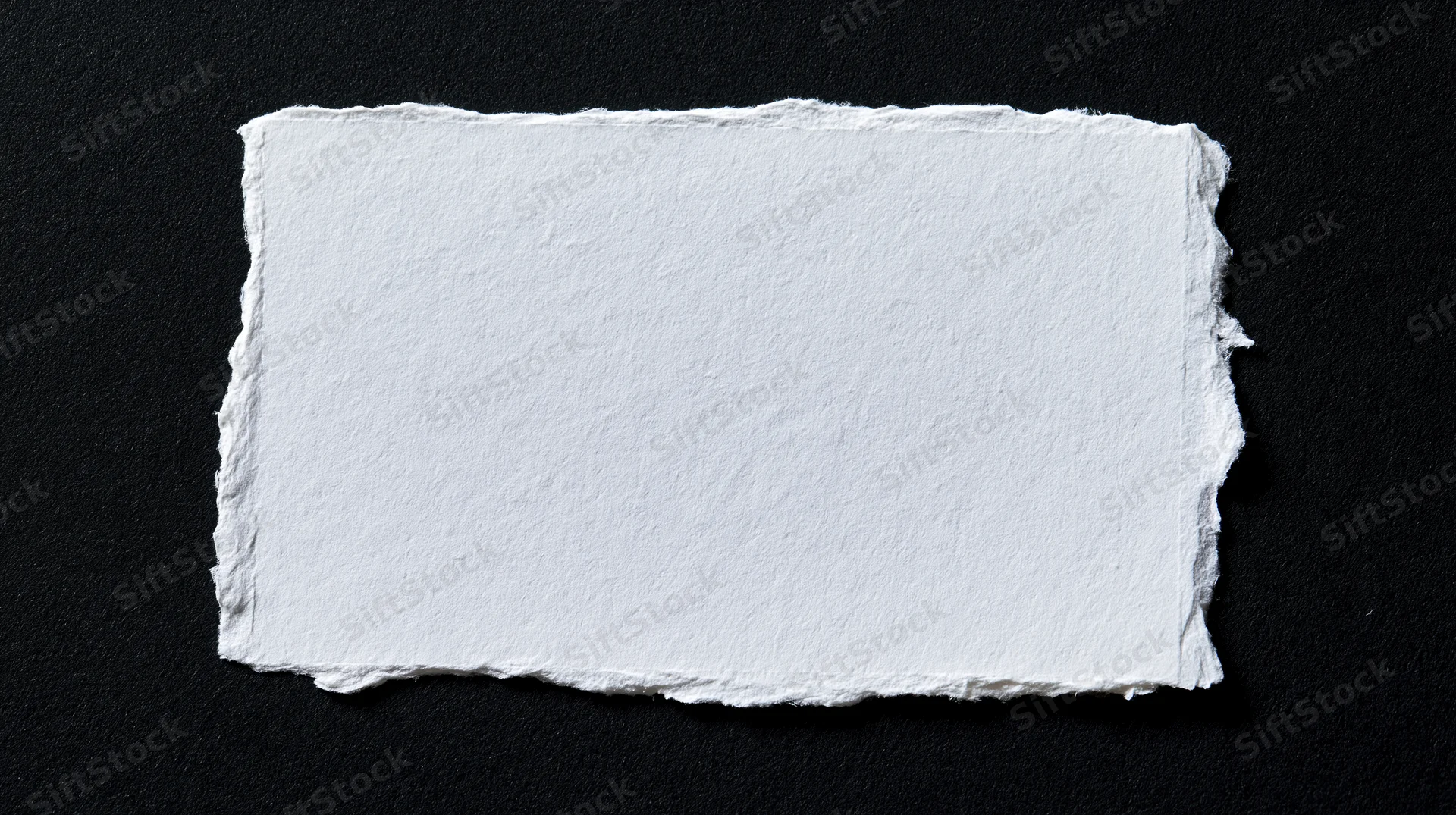 Torn white paper rectangle on black background with copyspace