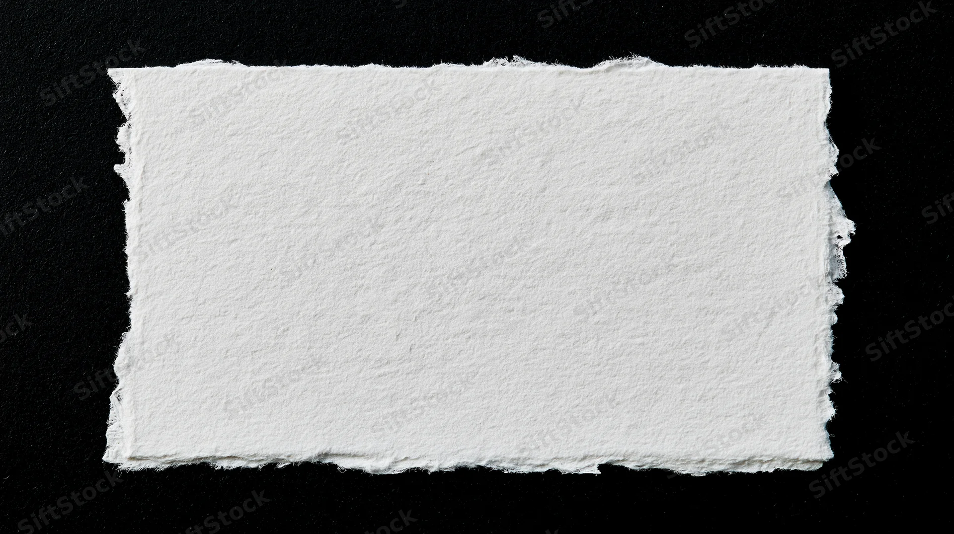 Torn white paper rectangle on black background with copyspace