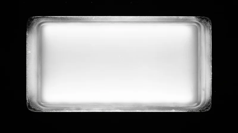 Overexposed blank film frame centered on pure black background