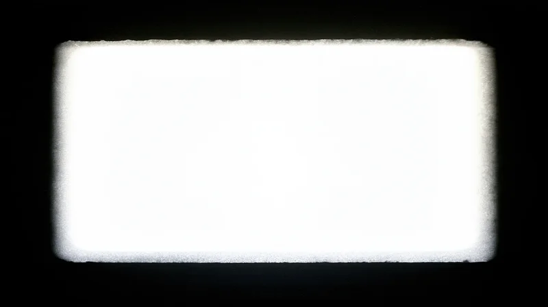 Overexposed blank film frame centered on black background with soft glowing edges