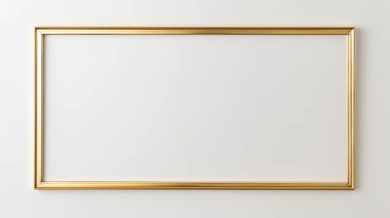 Gold rectangular picture frame lying flat on white surface with blank interior for design placement