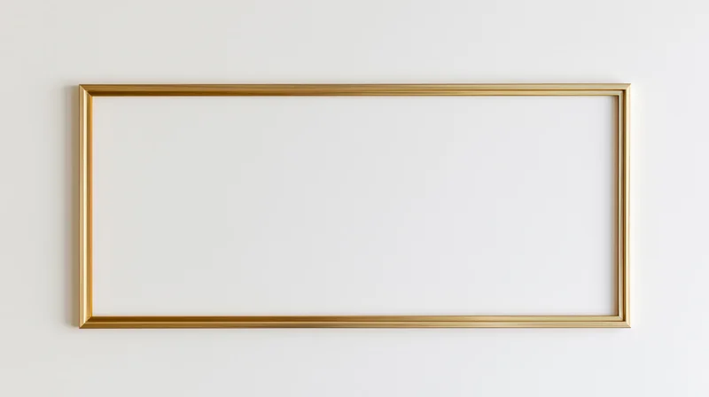 Thin gold rectangular frame hanging on a white wall with blank interior
