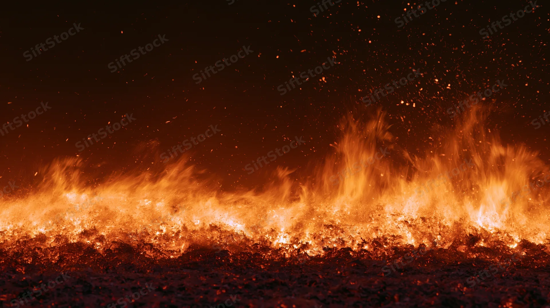 Intense fire burning along the bottom of the frame at night