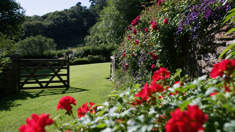 Open wooden gate leading into a manicured lawn surrounded by blooming red and purple flowers in an english country garden