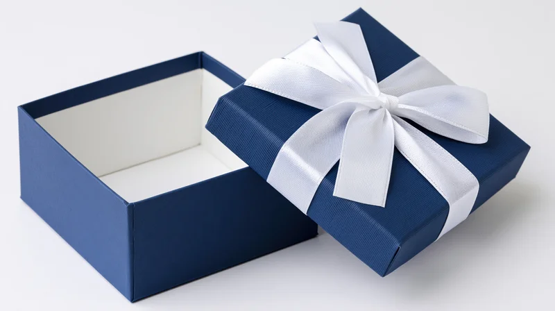 Open blue gift box with white ribbon bow on white background