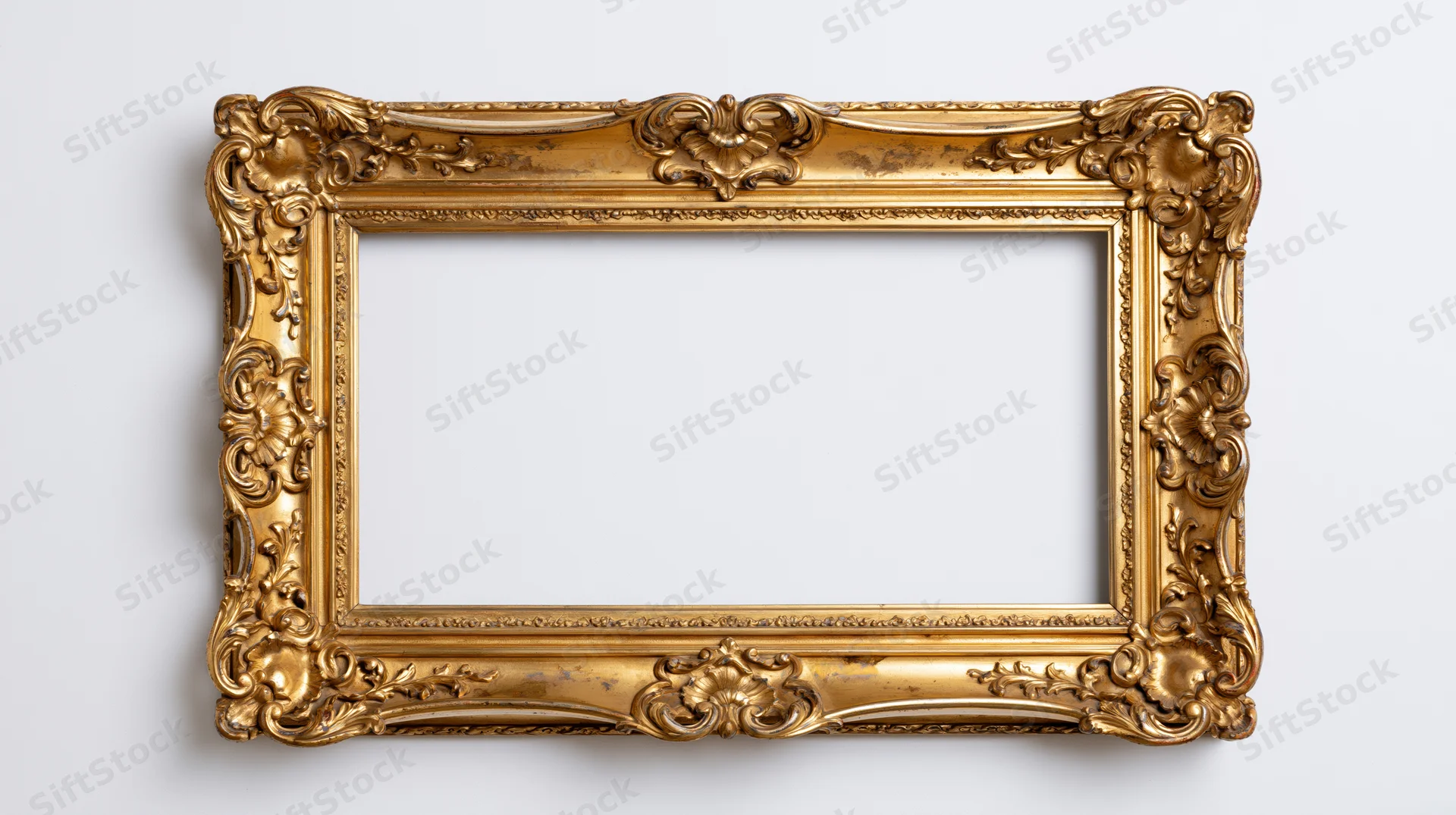 Ornate gold baroque frame with floral carvings hanging on white wall