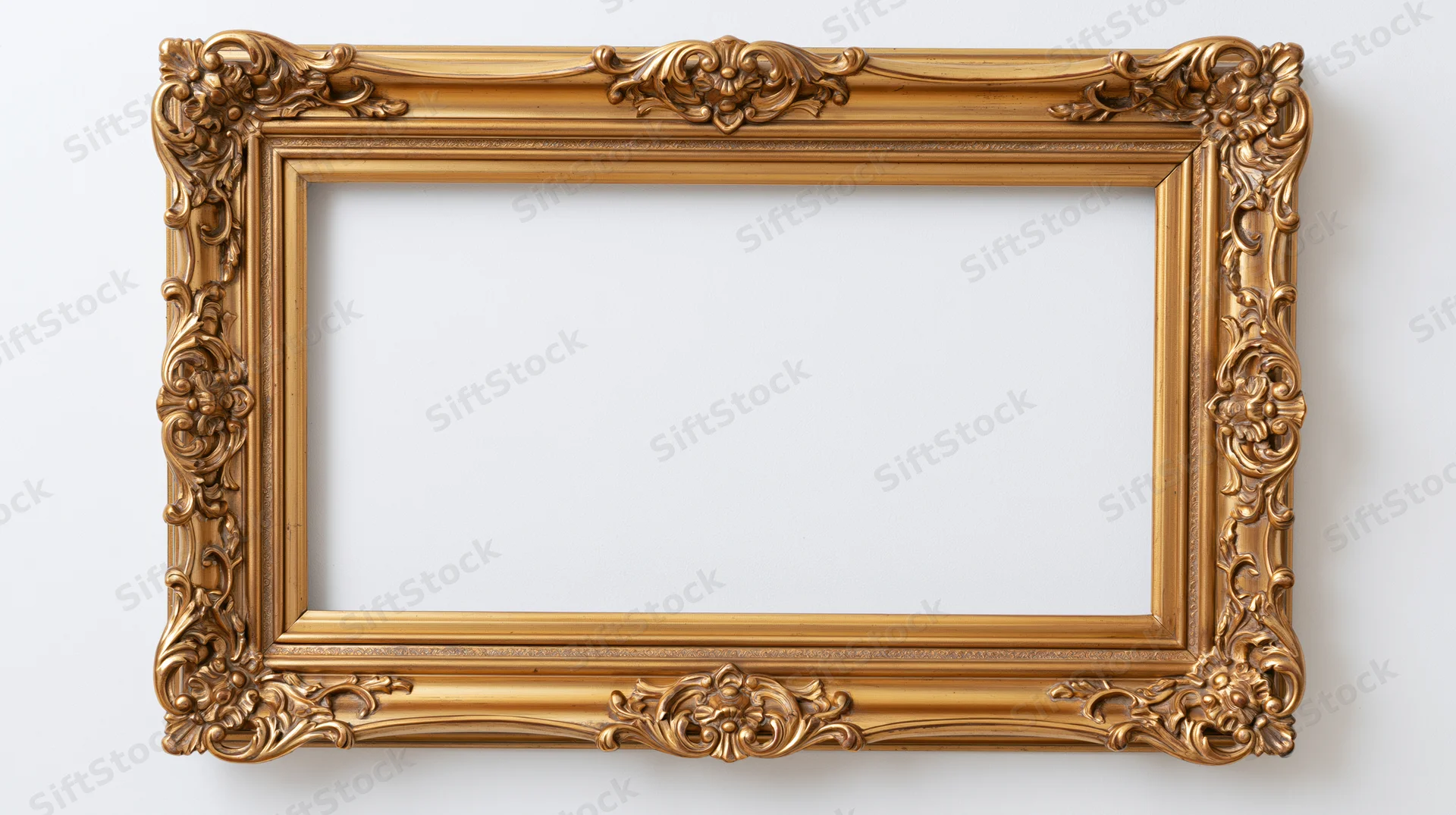 Ornate gold baroque frame with floral carvings hanging on a white wall