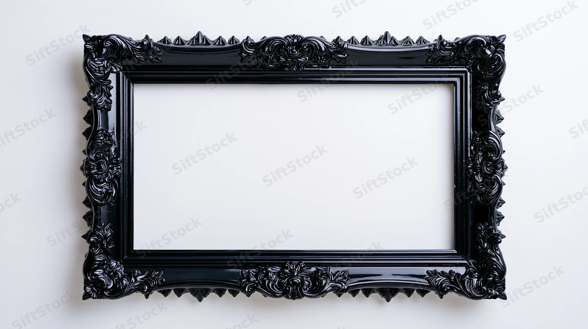 Ornate black gothic baroque-style frame hanging on a white wall with empty center for display