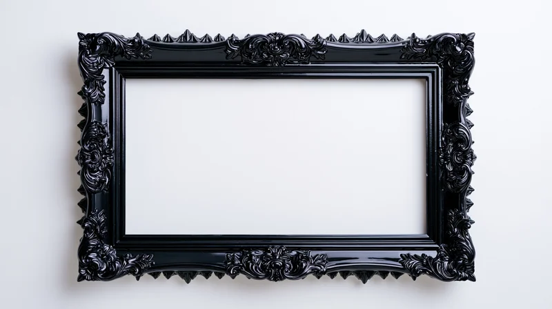 Ornate black gothic baroque-style frame hanging on a white wall with empty center for display