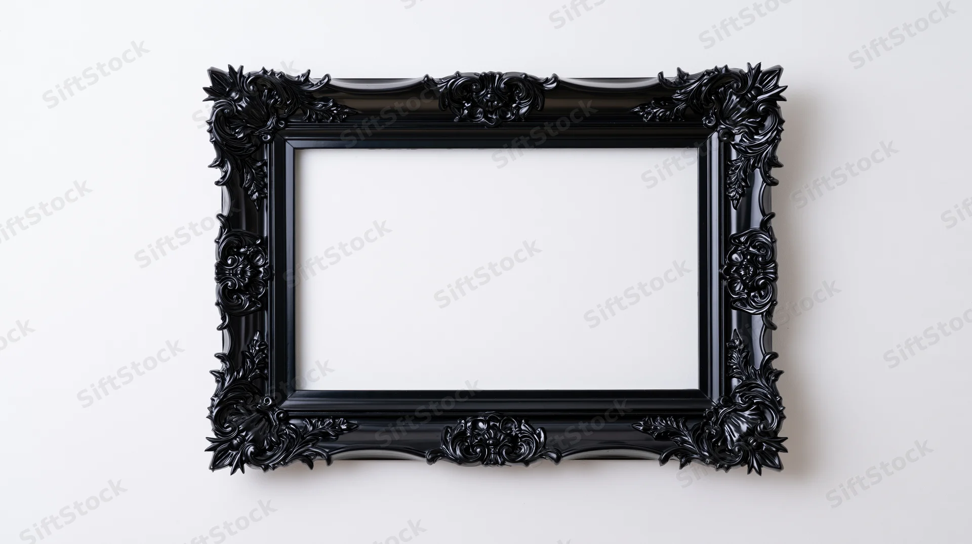 Ornate black gothic baroque frame with intricate carvings hanging on a white wall