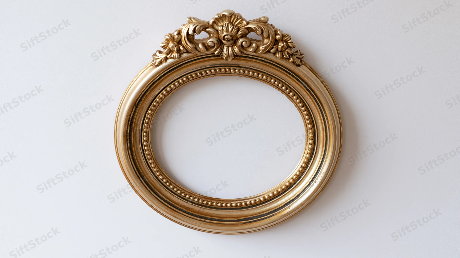 Ornate gold circular frame with baroque carvings hanging on a white wall