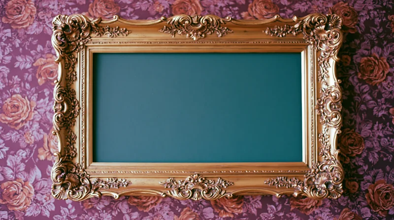 Ornate gold baroque frame with carved detailing hanging on floral wallpapered wall